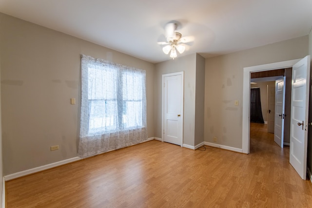 unfurnished bedroom with ceiling fan, a closet, and light wood-type flooring