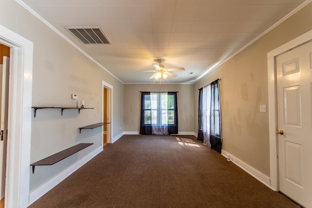 empty room with ornamental molding, dark colored carpet, and ceiling fan