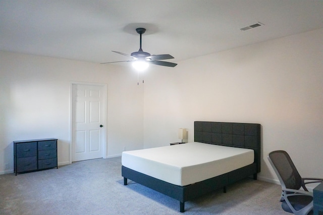 carpeted bedroom featuring a ceiling fan, visible vents, and baseboards