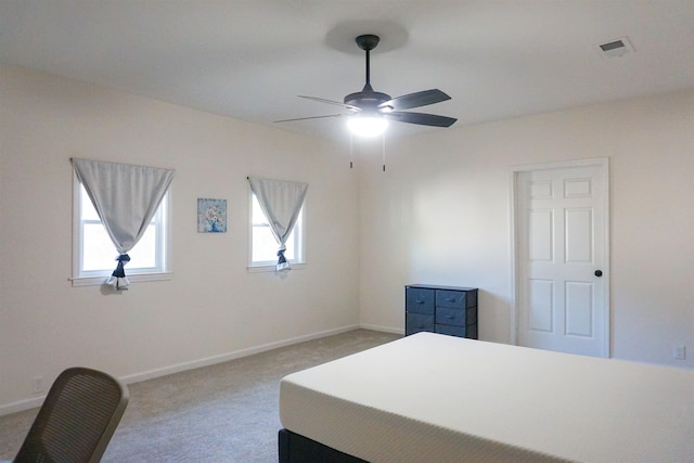 carpeted bedroom with visible vents, baseboards, and ceiling fan