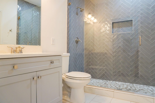 full bath featuring tile patterned flooring, vanity, toilet, and a shower stall