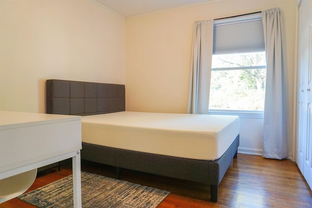 bedroom featuring ornamental molding and dark wood-type flooring