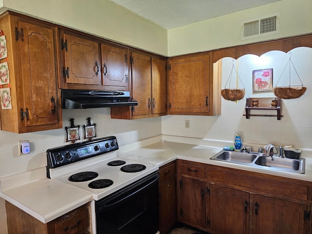 kitchen with electric stove, a textured ceiling, and sink