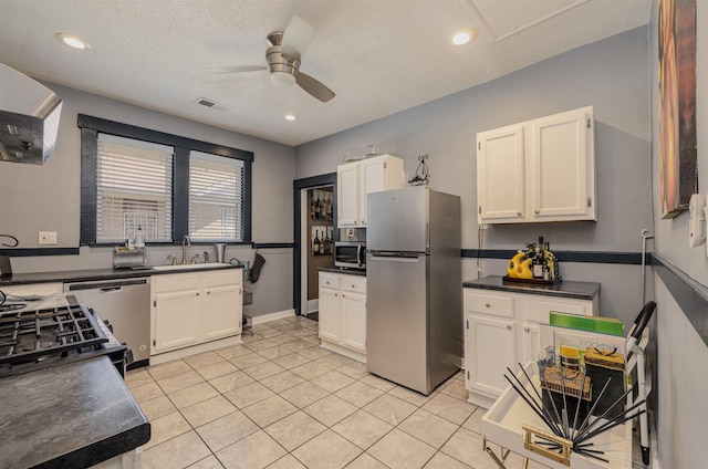 kitchen featuring dark countertops, visible vents, stainless steel appliances, and a sink