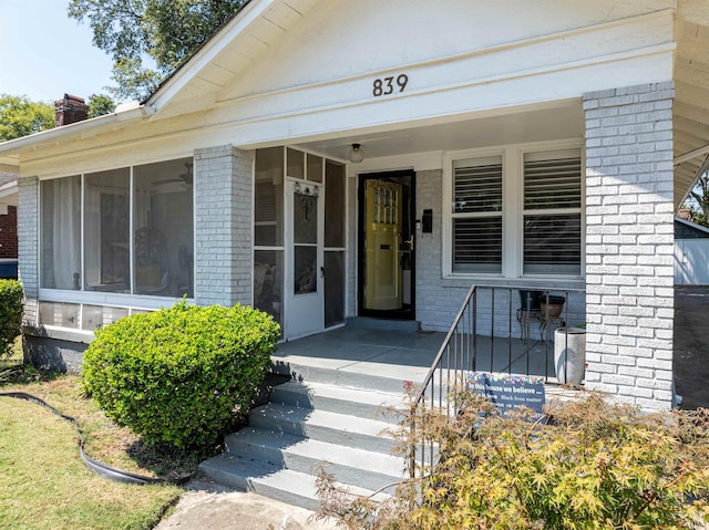 view of exterior entry featuring brick siding