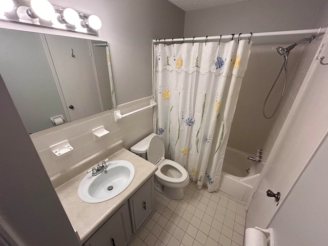 full bathroom featuring toilet, tile patterned floors, vanity, backsplash, and shower / bath combo