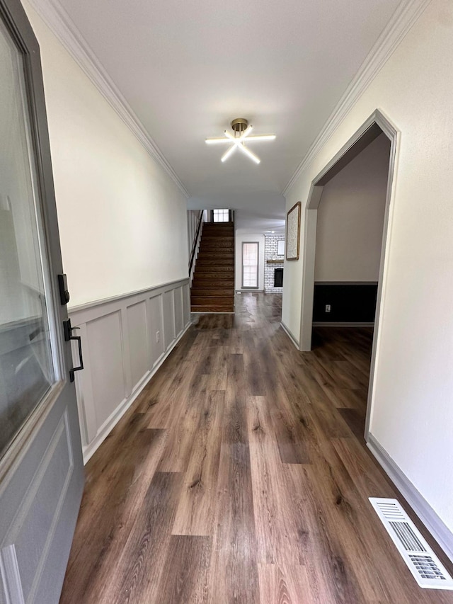 interior space featuring ornamental molding, wood finished floors, stairs, and visible vents