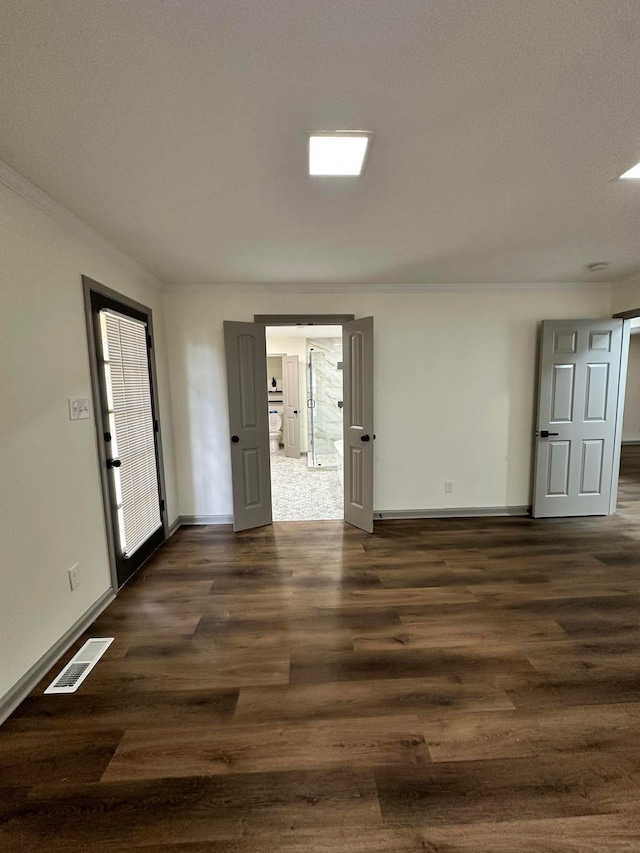 empty room featuring baseboards, visible vents, and dark wood finished floors