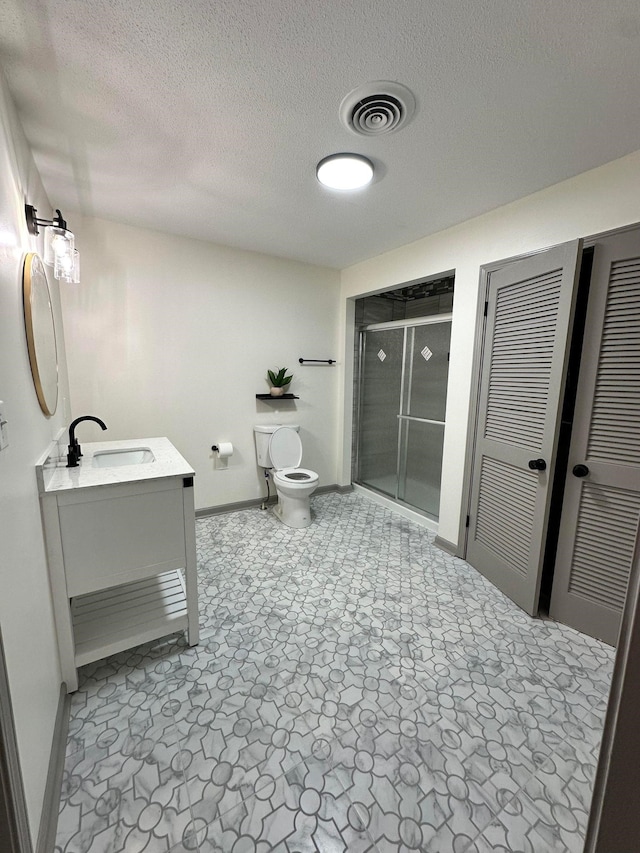 full bathroom with a stall shower, vanity, baseboards, toilet, and visible vents