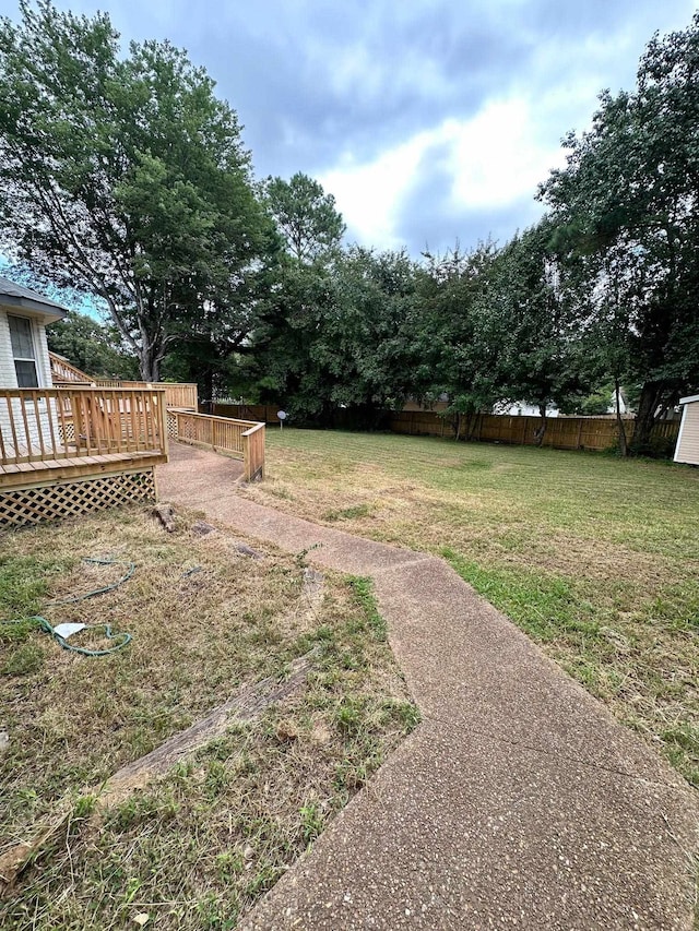 view of yard featuring fence and a deck