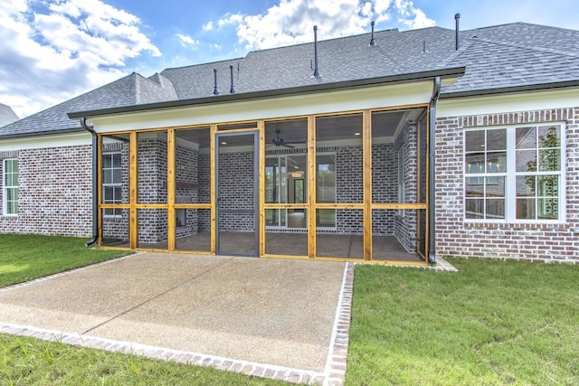 back of house with a sunroom and a lawn