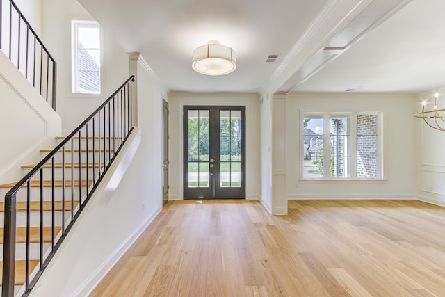 entrance foyer featuring crown molding, french doors, and light hardwood / wood-style flooring