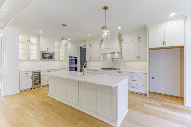 kitchen featuring white cabinets, beverage cooler, and appliances with stainless steel finishes