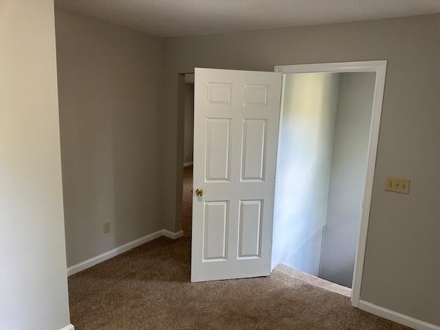 empty room featuring carpet flooring and a textured ceiling