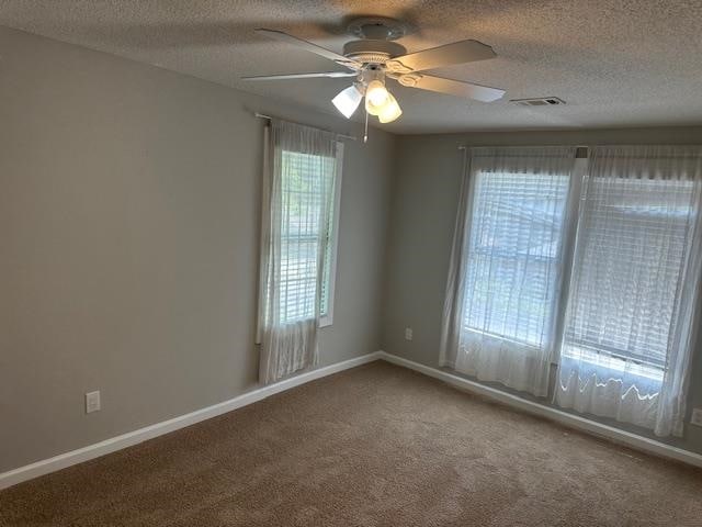 carpeted empty room with a textured ceiling and ceiling fan