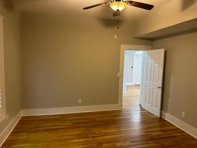 empty room featuring wood-type flooring and ceiling fan