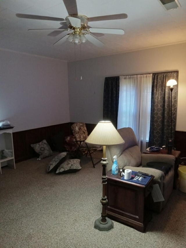 living room with carpet floors, visible vents, and a ceiling fan