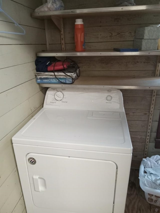 laundry room featuring washer / clothes dryer, wooden walls, and laundry area