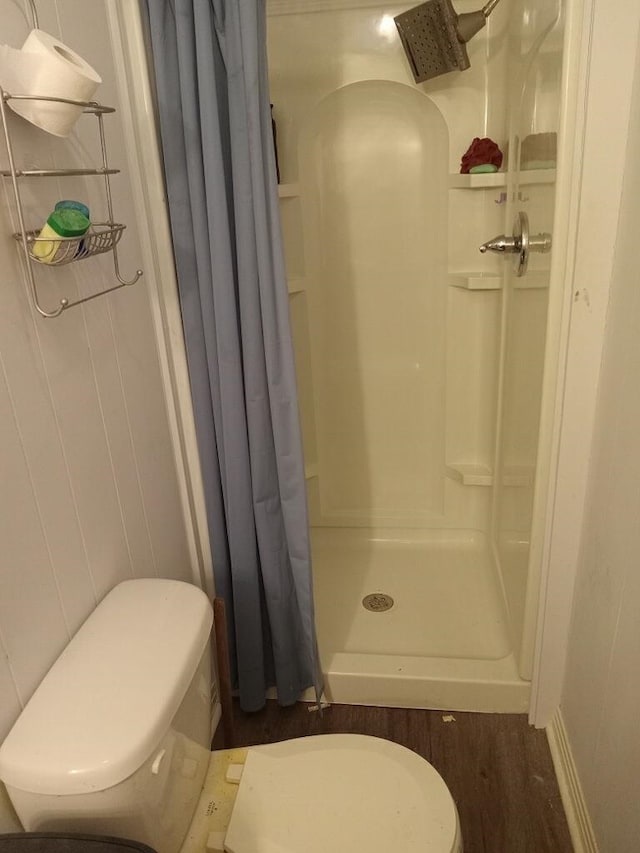 full bathroom featuring a shower stall and toilet