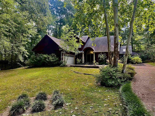 view of front of property featuring a front yard, roof with shingles, and an attached garage