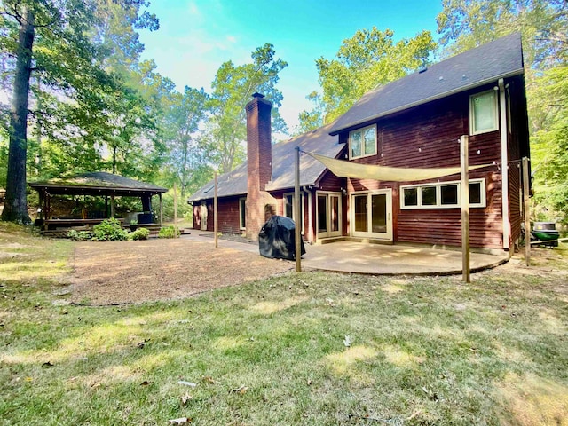 back of property featuring a gazebo, a lawn, and a patio