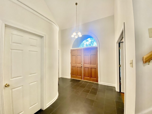 entrance foyer featuring a chandelier, baseboards, and vaulted ceiling