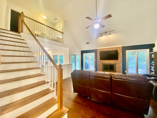 living room with a fireplace, a wealth of natural light, wood-type flooring, and ceiling fan