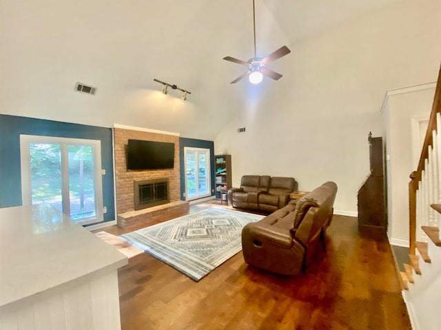 living room with ceiling fan, high vaulted ceiling, dark hardwood / wood-style flooring, and a fireplace