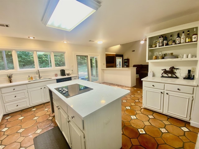 kitchen with a sink, light countertops, white cabinetry, visible vents, and black appliances