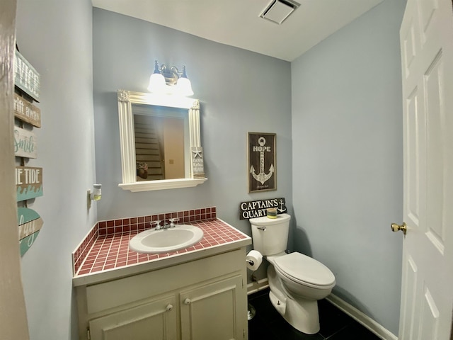bathroom featuring toilet, vanity, baseboards, and visible vents