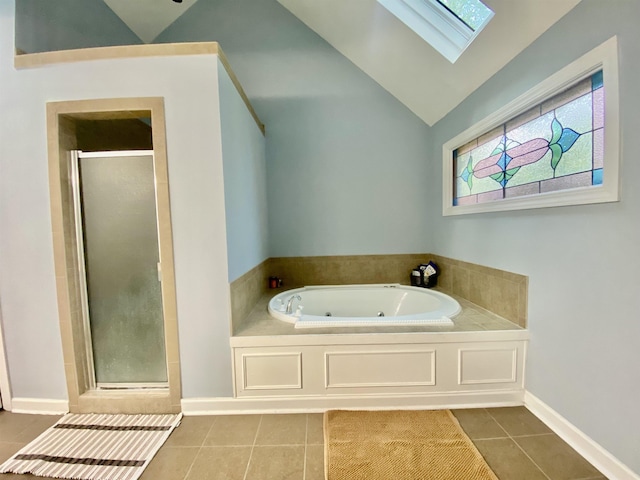 bathroom with a shower stall, a tub with jets, tile patterned flooring, baseboards, and lofted ceiling with skylight