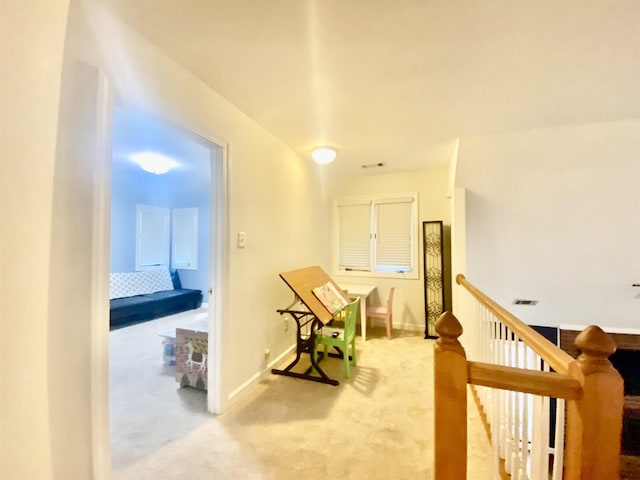 hallway featuring visible vents, baseboards, an upstairs landing, and carpet