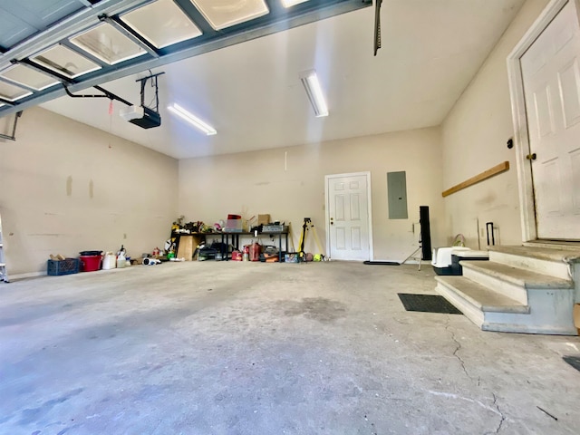 garage with a garage door opener and electric panel