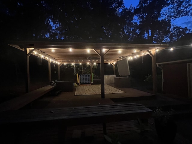 patio at night featuring a pergola