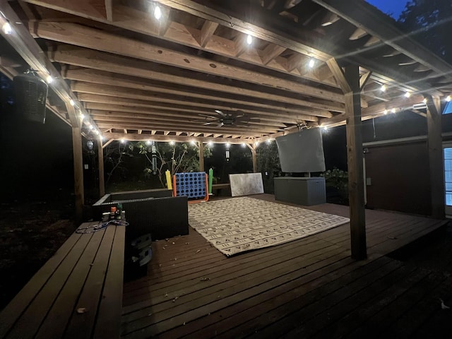 deck at night featuring ceiling fan