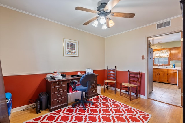 office area featuring light wood-type flooring, ceiling fan, sink, and ornamental molding