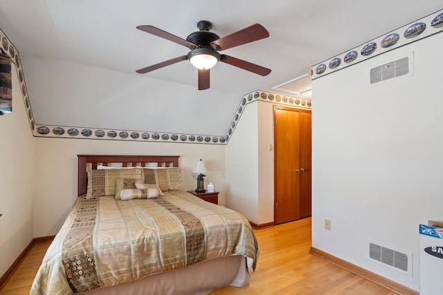 bedroom featuring lofted ceiling, light hardwood / wood-style flooring, and ceiling fan