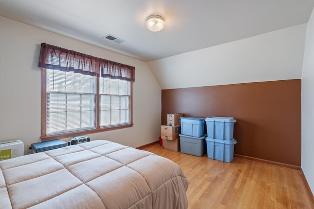 bedroom with light wood-type flooring and lofted ceiling