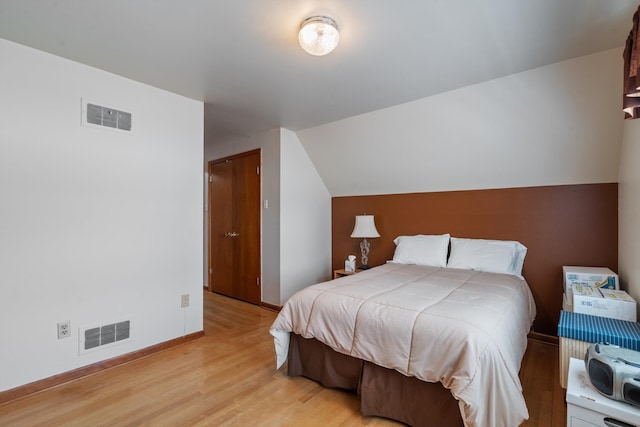 bedroom with light hardwood / wood-style flooring and vaulted ceiling