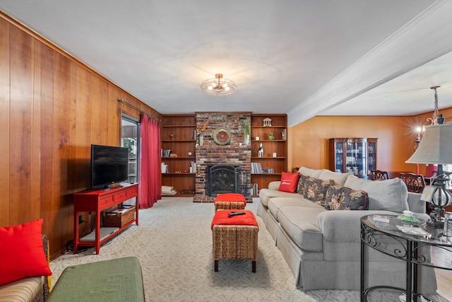 carpeted living room with built in features, crown molding, wood walls, and a fireplace