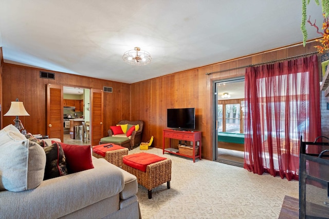 living room with wood walls and light carpet