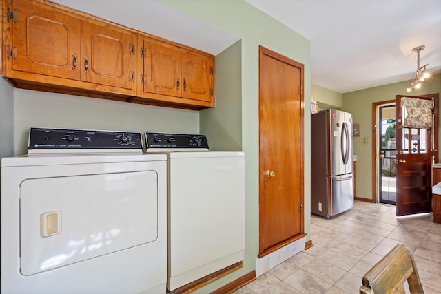 clothes washing area with light tile patterned floors and washer and clothes dryer