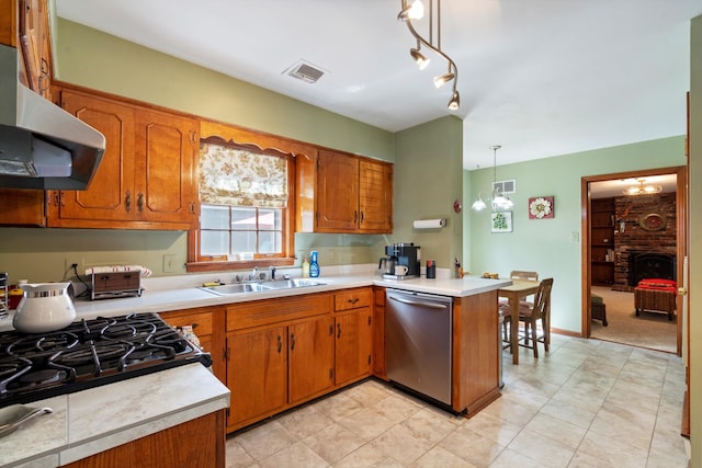 kitchen with a fireplace, a notable chandelier, decorative light fixtures, dishwasher, and sink