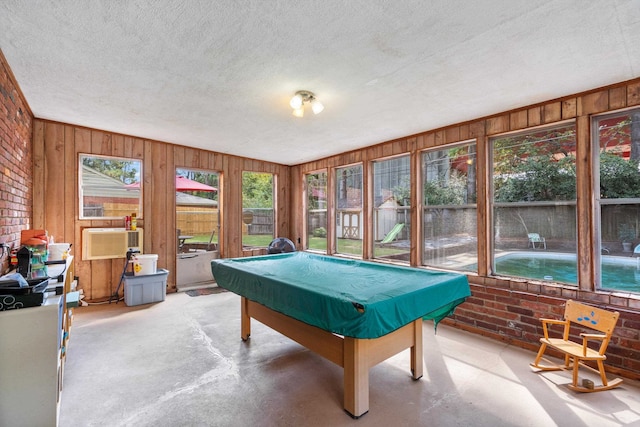 playroom with a textured ceiling, concrete floors, and pool table