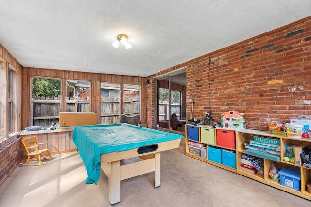 game room with a wealth of natural light, billiards, concrete flooring, and a textured ceiling