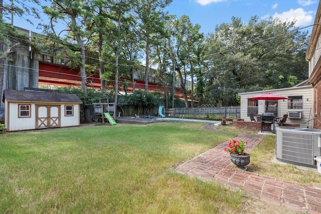 view of yard with cooling unit, a shed, and a patio