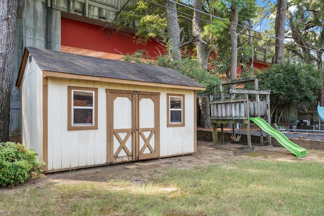 view of outbuilding featuring a lawn and a playground