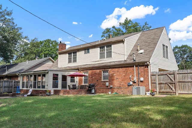 back of property featuring a lawn, a patio, and central air condition unit