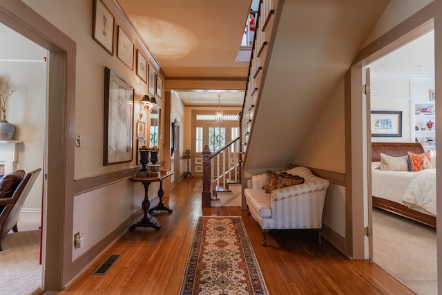 corridor with crown molding, dark hardwood / wood-style floors, and a chandelier