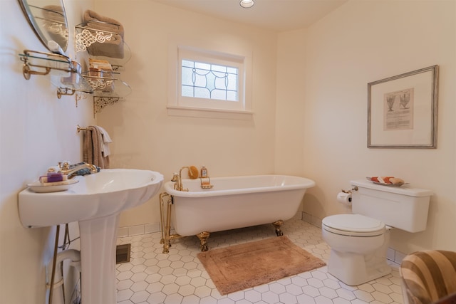 bathroom with toilet, a bathtub, and tile patterned floors